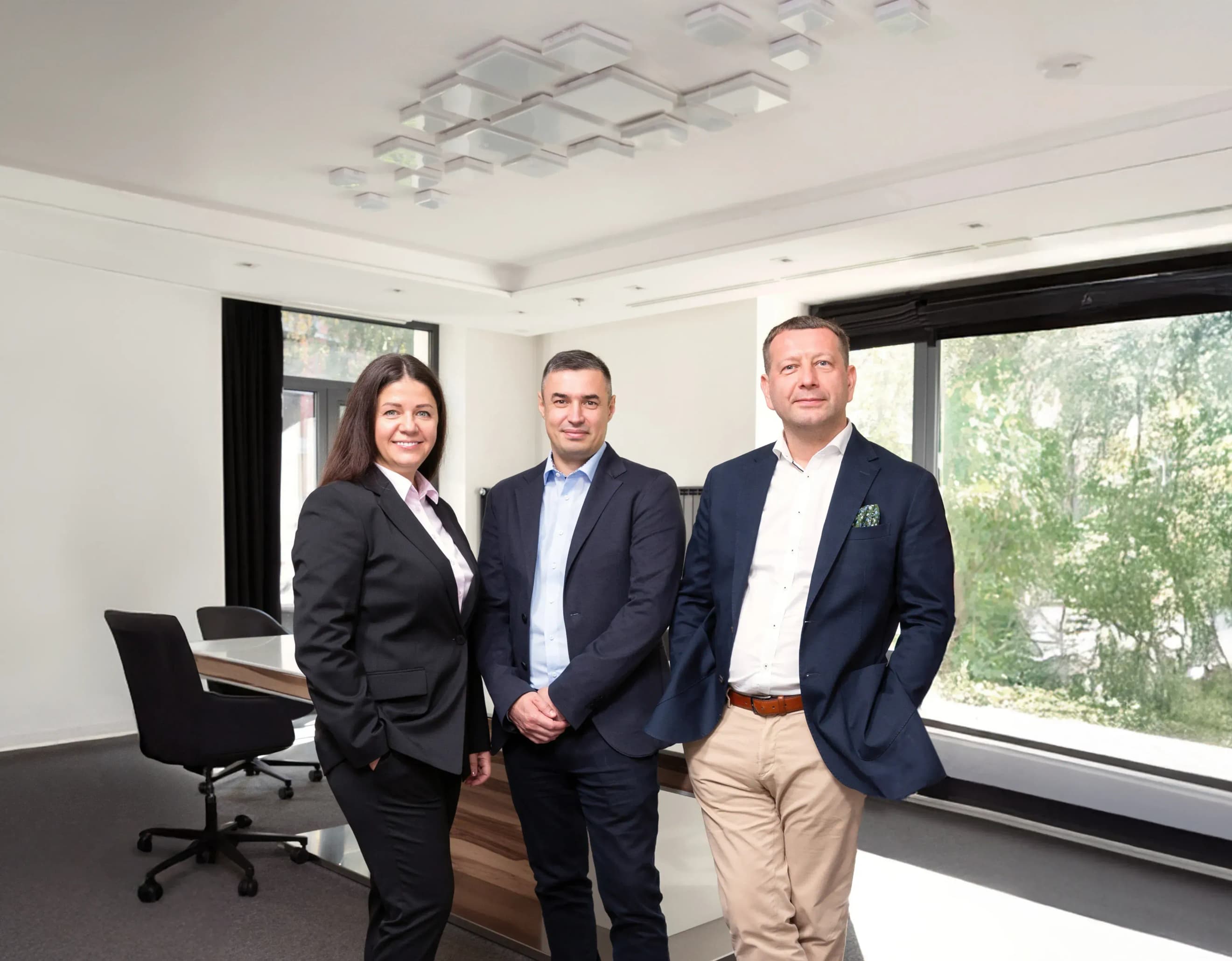 Жінка і двоє чоловіків одягнені в костюми в офісі Жінка і двоє чоловіків одягнені в костюми в офісі