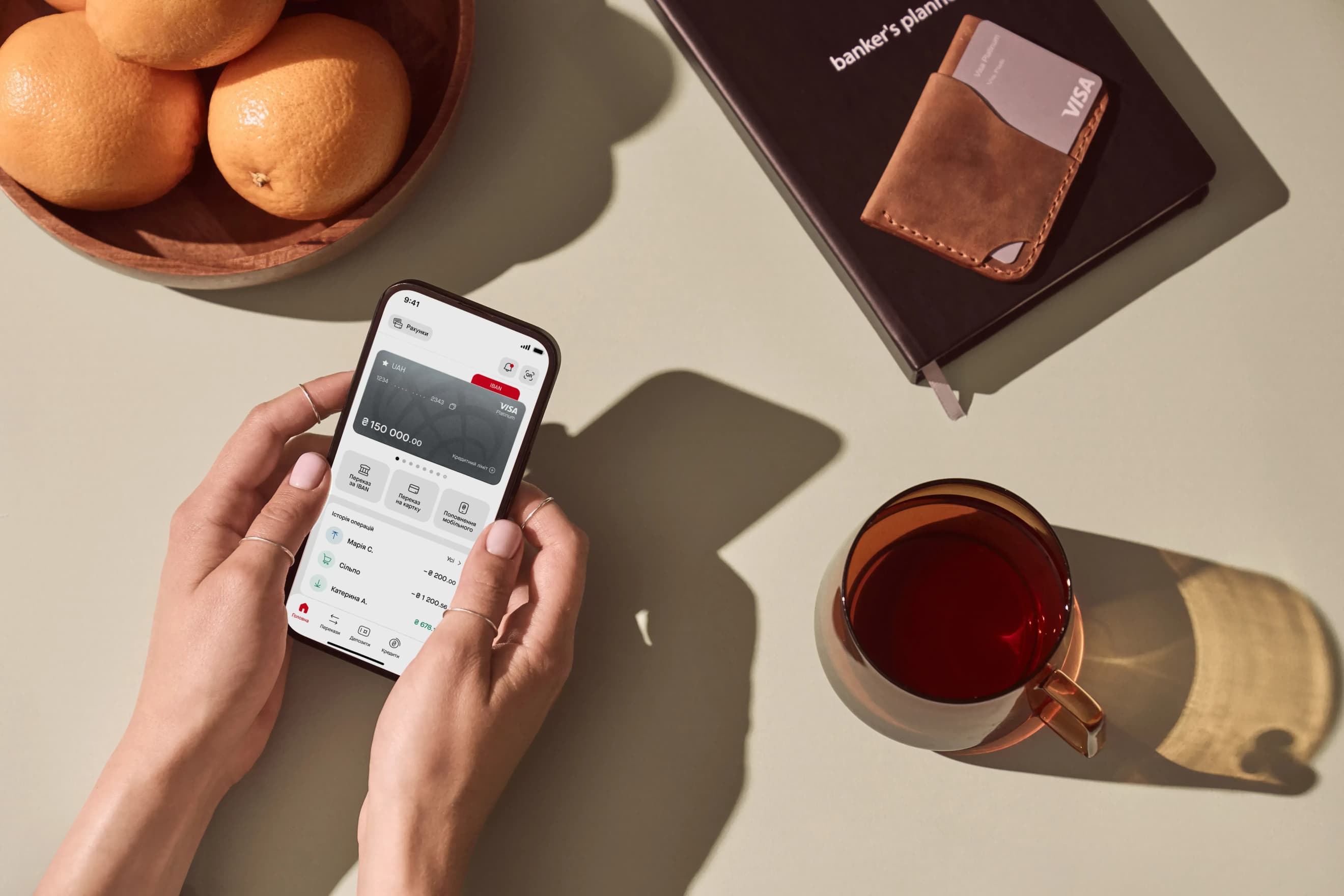 У руках смартфон із відкритим головним екраном мобільного застосунку ПроКредит Банку. У руках смартфон із відкритим головним екраном мобільного застосунку ПроКредит Банку.